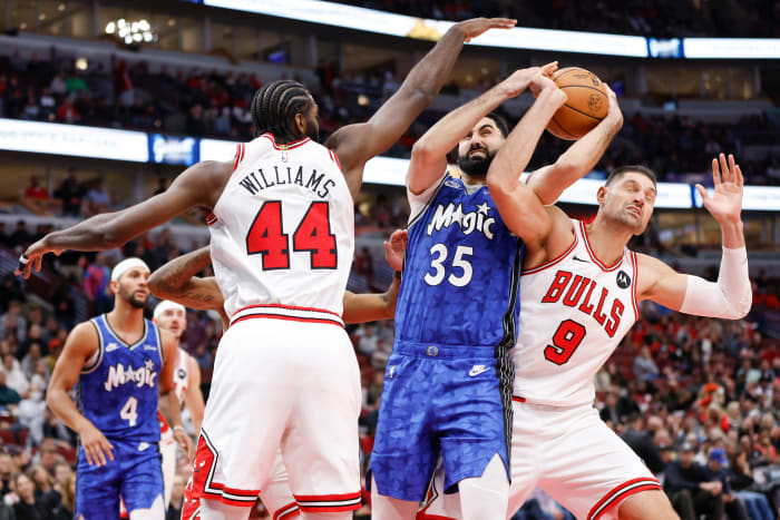 Orlando Magic center Goga Bitadze (35) battles for the ball with Chicago Bulls forward Patrick Williams (44) and center Nikola Vucevic (9) during the second half at United Center.